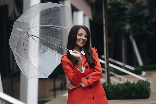 Europese model poseren in de buurt van de boetiek. Jonge elegante meisje staande met paraplu in straat. — Stockfoto