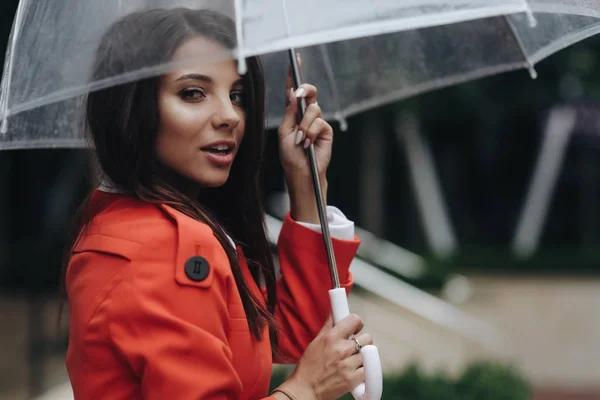 Close up woman portrait of young pretty girl posing at the city. Portrait of young woman in coat holding umbrella. Young smiling woman with umbrella on city street — Stock Photo, Image