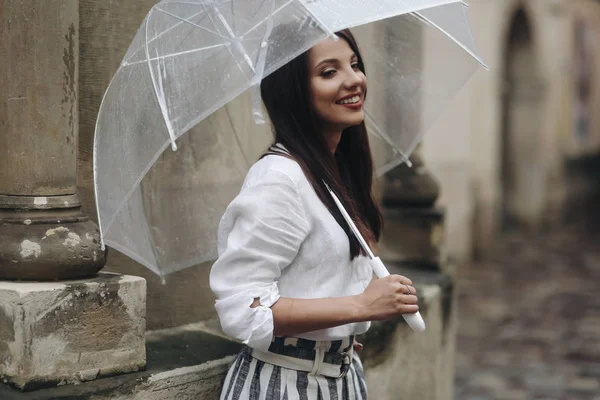 Portrait d'une fille heureuse avec parapluie près de la vieille maison. Espace de copie. C'est la pluie d'été . — Photo