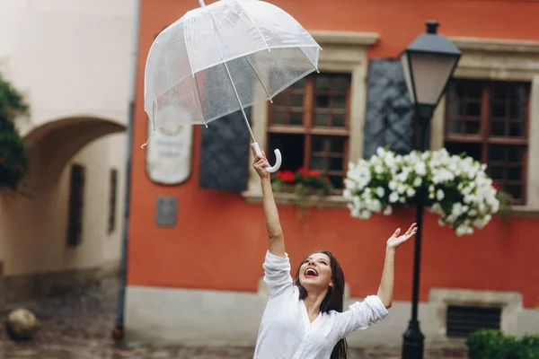 Horizontales Porträt einer positiven und schönen Frau, die den Sommertag am Wochenende genießt. Es regnet im Sommer. — Stockfoto