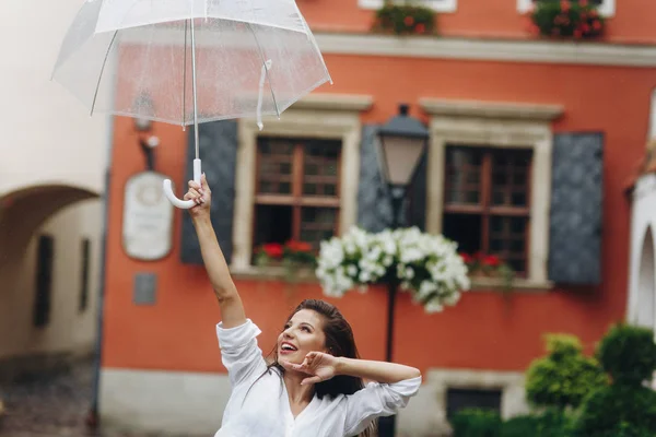 Retrato horizontal de mujer joven con paraguas caminando por la ciudad de verano al aire libre. Es lluvia de verano. . — Foto de Stock