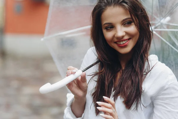 Close up portrait of a happy woman under an umbrella near old house. Copy space. It's summer rain. — Stock Photo, Image