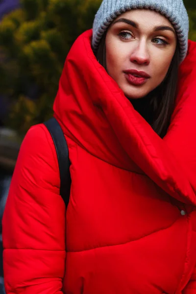 站在冬季街道上的穿着红色羽绒服的年轻迷人女人的特写肖像 穿着保暖衣服的梦幻女郎的户外照片 城市生活方式 — 图库照片
