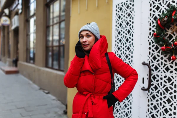전화에 이야기 거리의 배경에 쾌활한 여자의 초상화 거리에 재킷에 크리스마스 — 스톡 사진