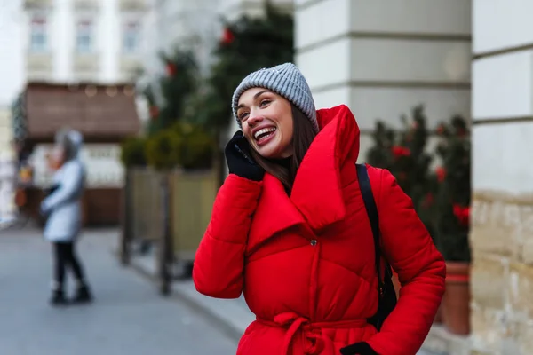 전화로 이야기 크리스마스 박람회의 배경에 쾌활한 거리에 재킷에 크리스마스 개념입니다 — 스톡 사진