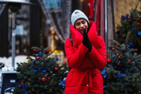 크리스마스 트리의 배경에 아름다운 여성의 초상화 크리스마스 박람회에 빨간색 재킷에 — 스톡 사진