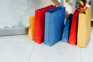 Renkli alışveriş çantaları alışveriş merkezinin zemininde yer almaktadır. E-ticaret dijital pazarlama yaşam tarzı kavramı. Alışveriş zamanı, kopyalama alanı