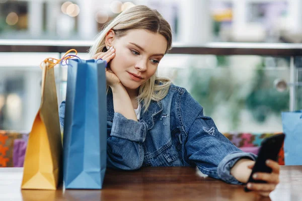 Portrait Beautiful Blonde Woman Jeans Jacket Shopping Bags Sitting Cafe — Stock Photo, Image