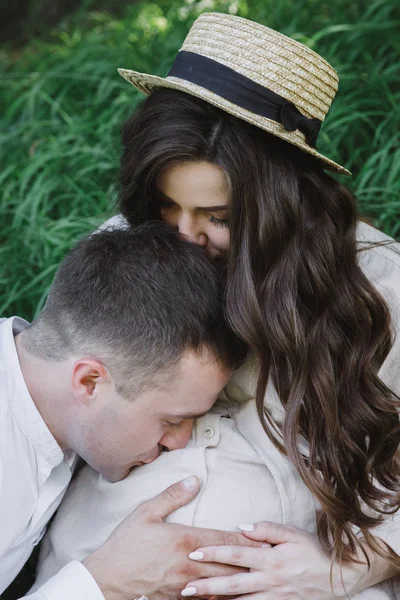 幸福伴侣的画像 坐在一起 一起在大自然上度过时光 漂亮的女人可爱的亲吻她的丈夫 男人把妻子抱在肚子里亲吻 — 图库照片