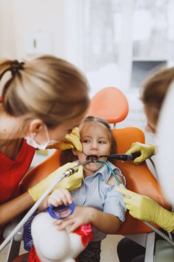 Çocuk dişlerini tedavi eden kadın dişçiler