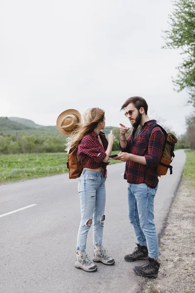 Dívka a přítel stojí na silnici a čeká na auto — Stock fotografie