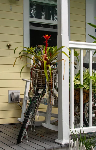 Tropik bitkiler ile bir ada tarzı evin rahatlatıcı bir ön verandada oturan madi gra tarzı boncuklar ile renkli bisiklet