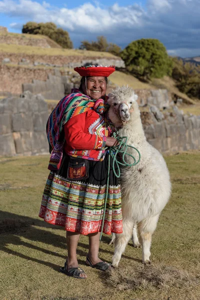Cuzco, Peru - 14 Temmuz 2018. Sacsayhuaman, Cusco, Peru, Güney Amerika'da alpaka / lama ile geleneksel renkli giysiler giymiş Perulu kadın.