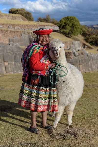Cuzco, Peru - 14 Temmuz 2018. Sacsayhuaman, Cusco, Peru, Güney Amerika'da alpaka / lama ile geleneksel renkli giysiler giymiş Perulu kadın.