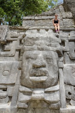 Maske Tapınağı 'nın tepesinde oturan turist, Lamanai Arkeolojik Rezerv, Orange Walk, Belize, Orta Amerika.