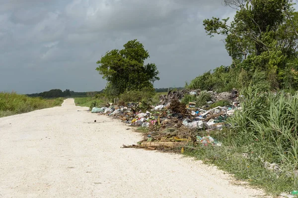 Orange Walk, Belize - 21 Mayıs 2017: Yolun kenarına atılan çöp öğütücüsü Latin Amerika 'daki yol kenarı çöp öğütücüsü sorununu vurguluyor.