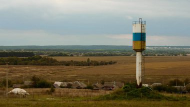 Watertower stand köyü yakınlarında. Bazı alanlar arkasında. Hava bulutlu.