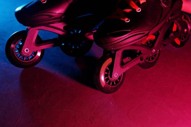 Neon mavi sagenta pembe ışık koyu grunge arka plan üzerinde paten inline paten veya rollerblading yakından görünümü