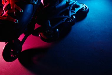 Neon mavi sagenta pembe ışık koyu grunge arka plan üzerinde paten inline paten veya rollerblading yakından görünümü
