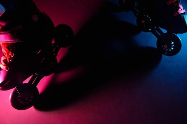Neon mavi sagenta pembe ışık koyu grunge arka plan üzerinde paten inline paten veya rollerblading yakından görünümü