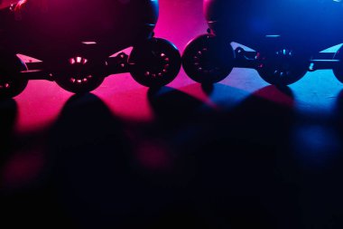 Neon mavi sagenta pembe ışık koyu grunge arka plan üzerinde paten inline paten veya rollerblading yakından görünümü