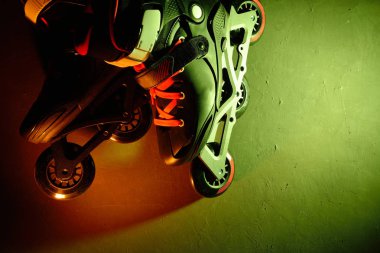 Neon mavi sarı yeşil ışık koyu grunge arka plan üzerinde paten inline paten veya rollerblading yakından görünümü