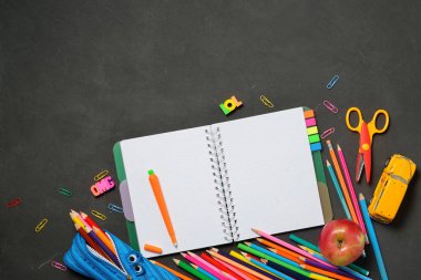 Back to School konsepti - siyah tebeşir arka plan üzerinde ofis ve öğrenci malzemeleri ile açık kopya kitap. Metin için alan.