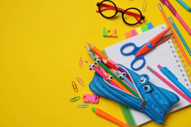 Renkli Back to School konsepti - sarı arka planda ofis ve öğrenci malzemeleri. Metin için alan.