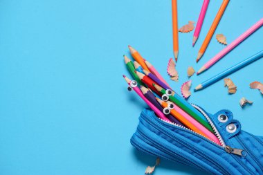 Funny Back to School konsepti - mavi arka planda kalem yeme kalem kutusu. Metin için alan.