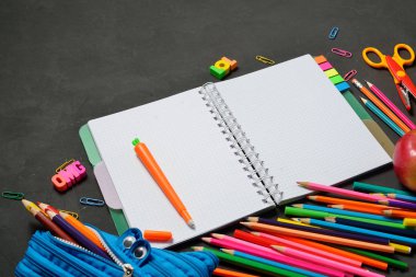 Back to School konsepti - siyah tebeşir arka plan üzerinde ofis ve öğrenci malzemeleri ile açık kopya kitap. Metin için alan.