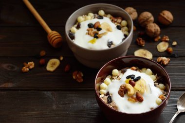 Süt, fındık, ahşap kahverengi arka plan üzerinde kurutulmuş meyve ile Müsli
