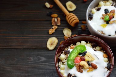 Granola yougurt, fındık, ahşap kahverengi arka plan üzerinde kurutulmuş meyve ile