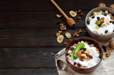 Granola yougurt, fındık, ahşap kahverengi arka plan üzerinde kurutulmuş meyve ile