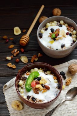 Süt, fındık, ahşap kahverengi arka plan üzerinde kurutulmuş meyve ile Müsli