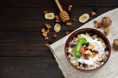 Granola yougurt, fındık, ahşap kahverengi arka plan üzerinde kurutulmuş meyve ile