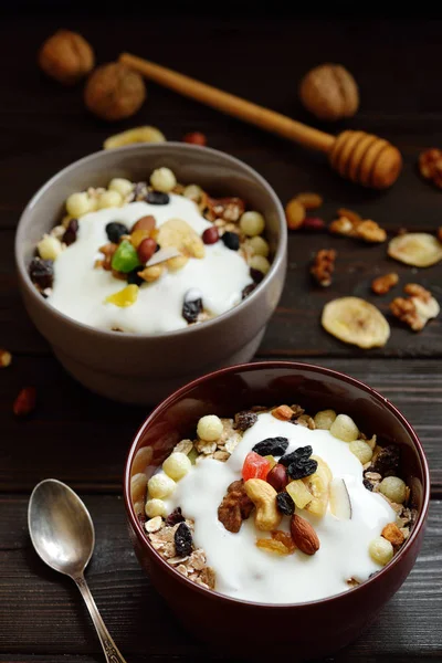 Granola yougurt, fındık, ahşap kahverengi arka plan üzerinde kurutulmuş meyve ile