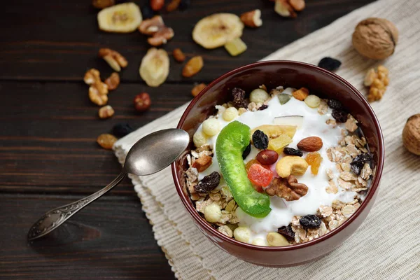 Granola yougurt, fındık, ahşap kahverengi arka plan üzerinde kurutulmuş meyve ile