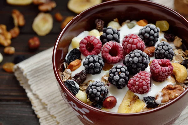 Süt, fındık, ahşap kahverengi arka plan üzerinde taze çilek ile Müsli