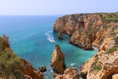 Gezi kumtaşı kayalıklarla ve mağarasını tekne ile popüler eğlence aktivite Lagos, Portekiz biridir. Bahar güneşli sabahı Algarve Sahili.