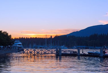 Gün batımında, Vancouver Bc, Kanada demirli gemiler ile Vancouver liman. Açık gökyüzü ve dağ ufukta güzel gün batımı.