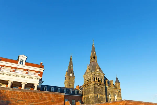 A view onto rooftops of Georgetown University buildings from Potomac River side of the campus. Beautiful historic buildings under a soft sunlight before sunset.