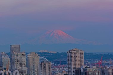 Gökyüzü pastel tonlar ünlü dağ güneş ışığı yanar. Kentsel Seattle panorama ve Mount Rainier ufukta gün batımında, Washington, ABD.