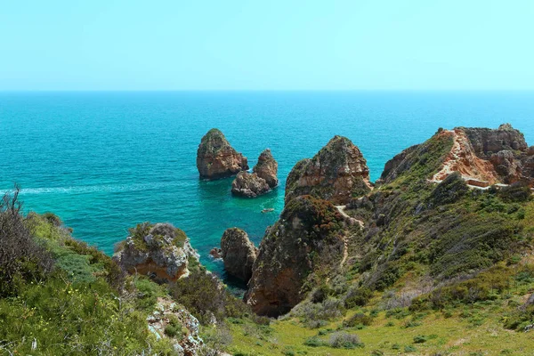 Yaya parkurları arasında uçurum turkuaz deniz suları doğal manzaralı ve kıyı hattı. Turistler Algarve, Portekiz motorbot üzerinde mağarasını keşfedin.