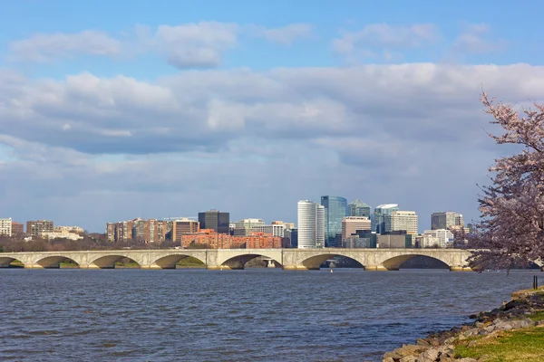 Arlington Memorial Bridge across Potomac River during cherry blossom season. Urban landscape of Arlington neighborhood skyscrapers, Virginia, USA.