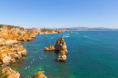 Lagos, Portekiz okyanus limanının güvenli sularda spor aktiviteleri. Kıyı şeridi panorama kumlu plajları, uçurumlar ve saf su ile bir bahar sabahı.