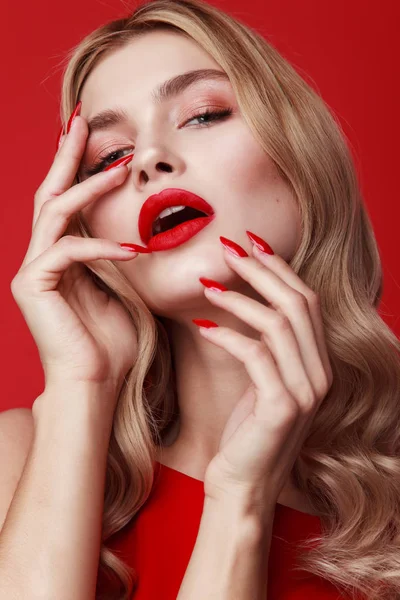close-up beauty shot. curly blonde woman isolated on red background. red long nails. gorgeous model. luxury make-up for young lady. stylish wavy hairstyle. Beautiful sexy blonde woman. Fashion photo of a beautiful elegant blonde woman