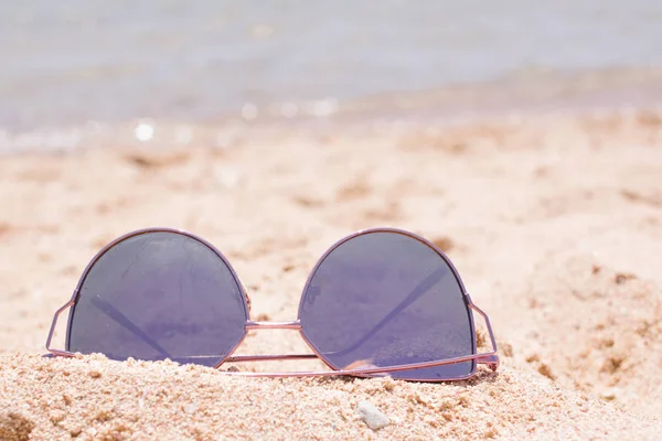 Sun glasses on the sand. sea view. woman on vacantion. relax at the beach