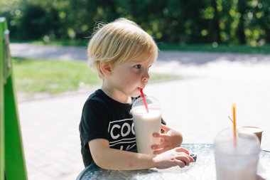 Sevimli çocuk, park, milkshake içme bahar. 