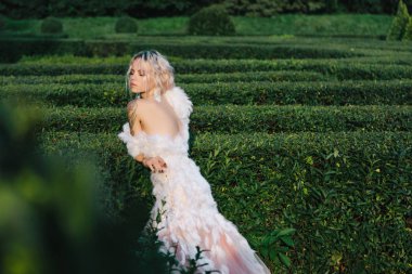 açık beyaz elbiseli güzel genç kadın. Romantik Bayan portre. Gelin parkta güzel bir uzun gelinlik yüzünden. Parkta yürüyüş vintage beyaz elbiseli güzel şık sarışın gelin. tüyleriyle elbise