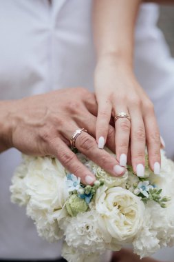 Gelin ve damat elleri bukette alyanslarla